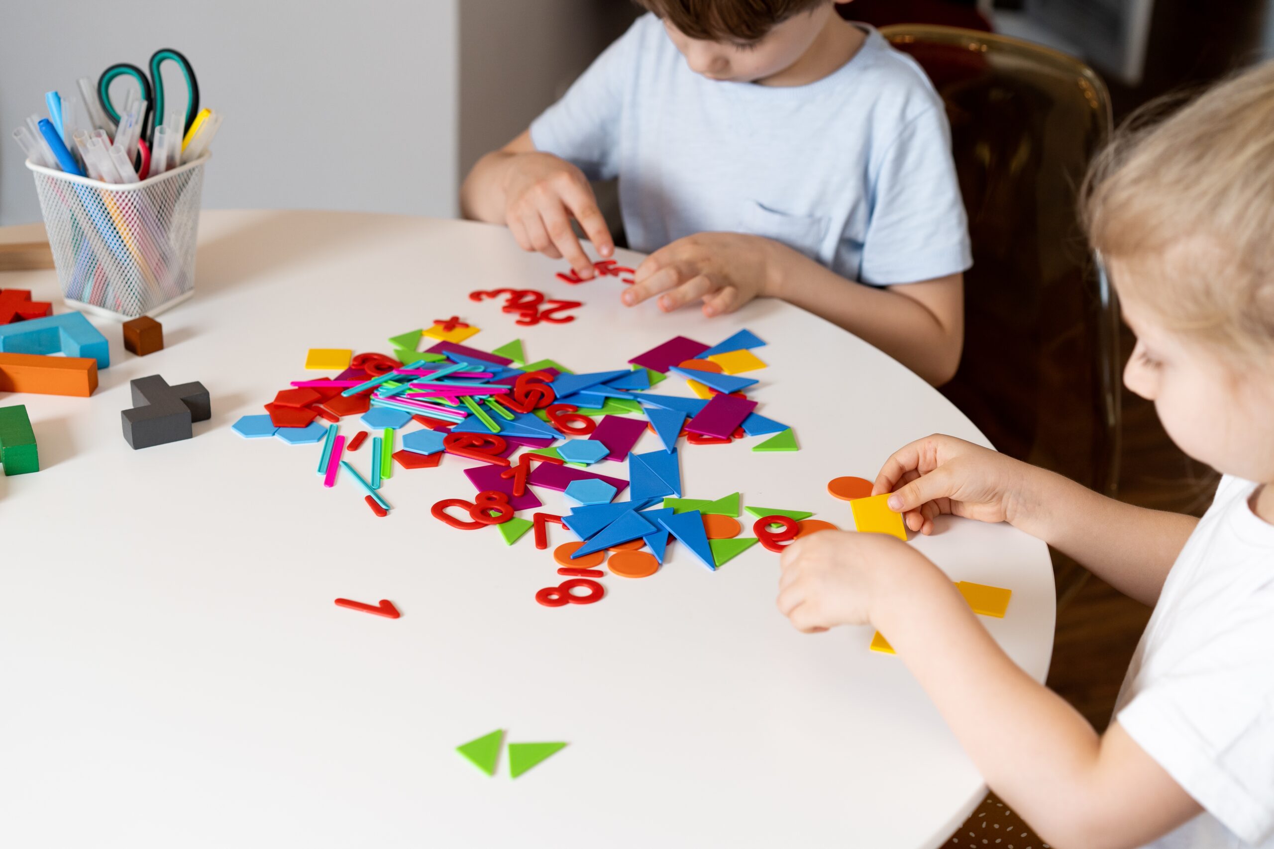 children playing with letter and shapes at a table in daycare